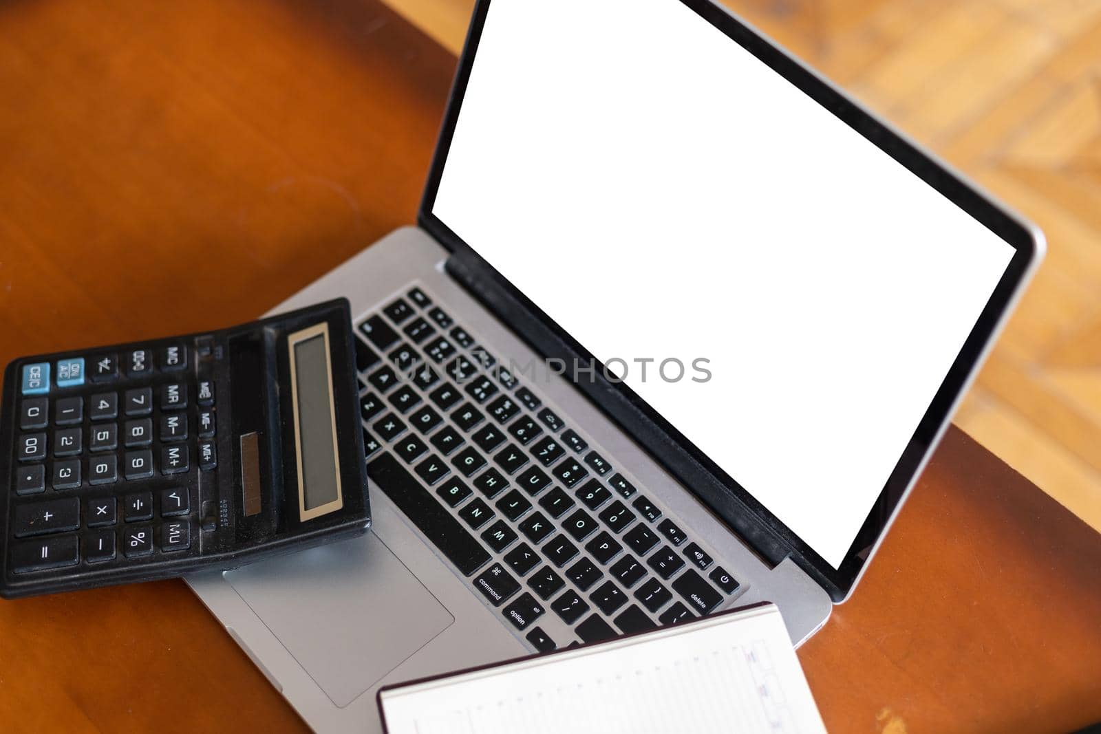 modern laptop computer with blank screen and copy space at workplace in office. Bills document, calculator and stationery on wooden table by Andelov13