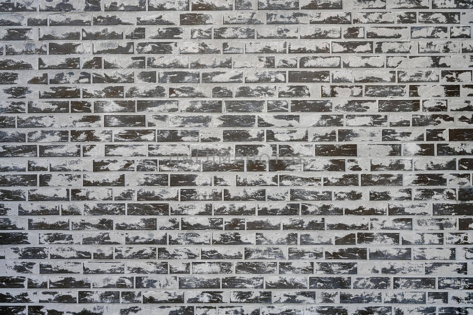 Grey brick wall with a lot of cement on the surface by elxeneize