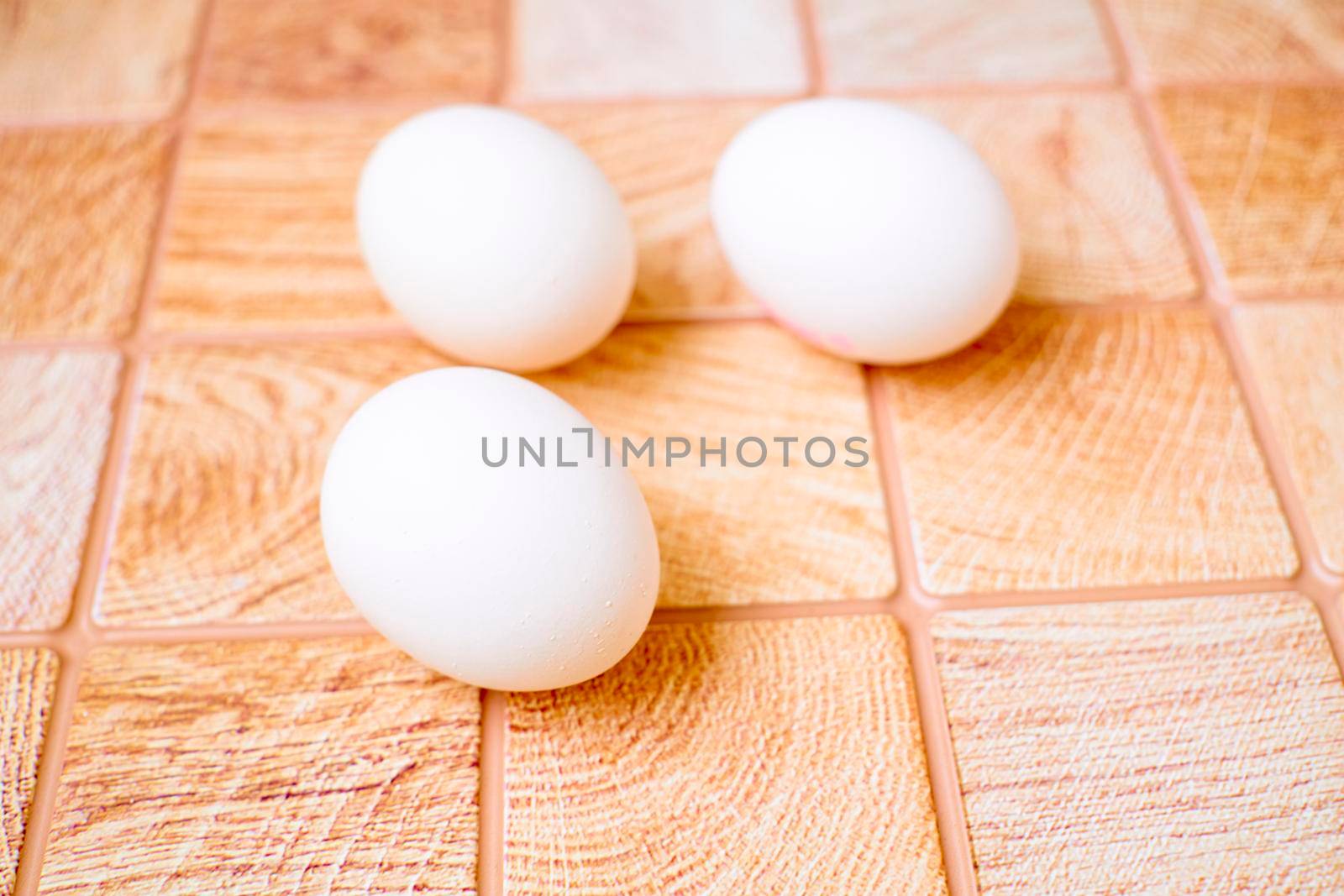 Three eggs on a pink wooden checkered background by jovani68