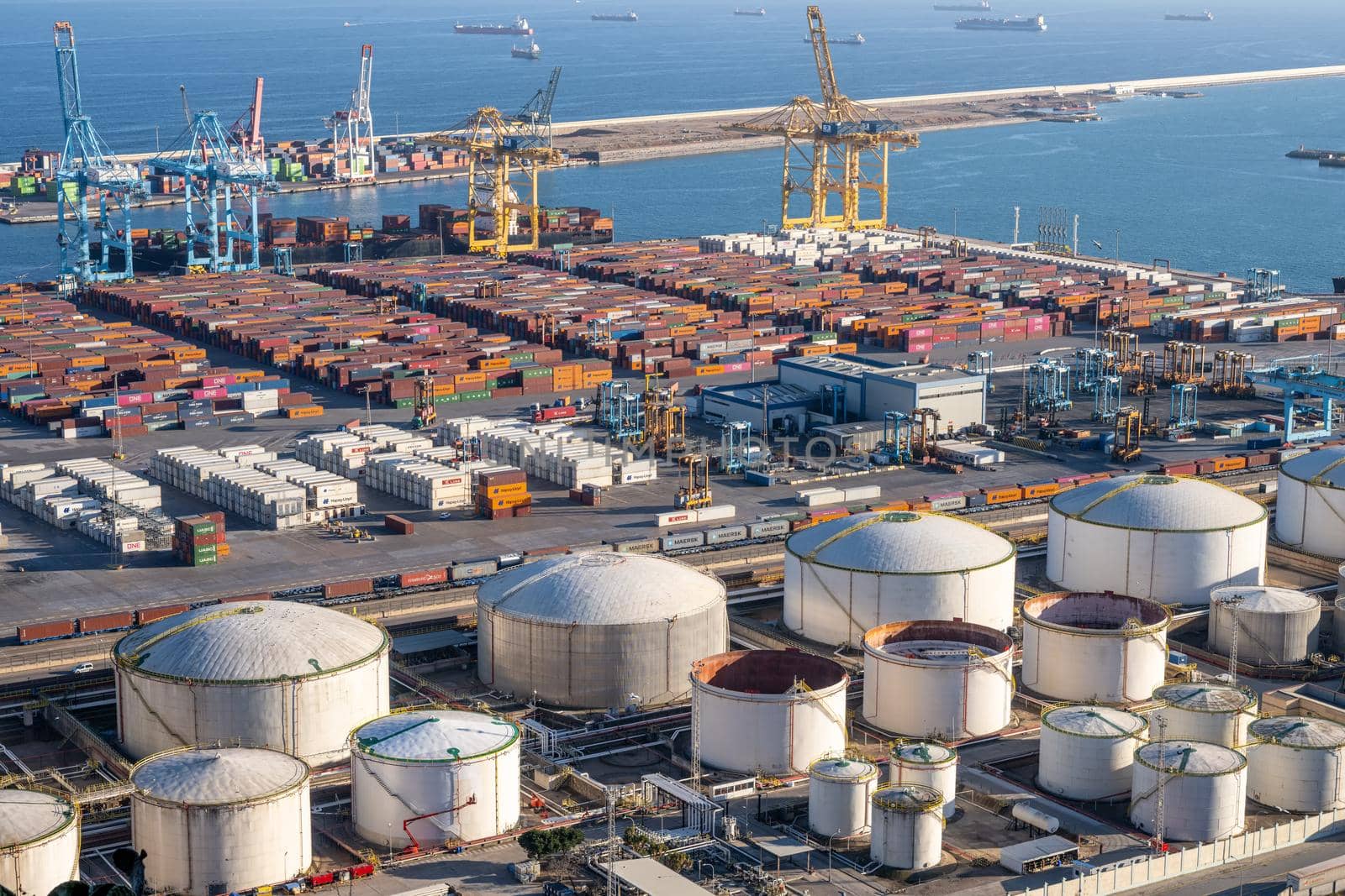 The commercial port of Barcelona with containers cranes and gas storage tanks by elxeneize