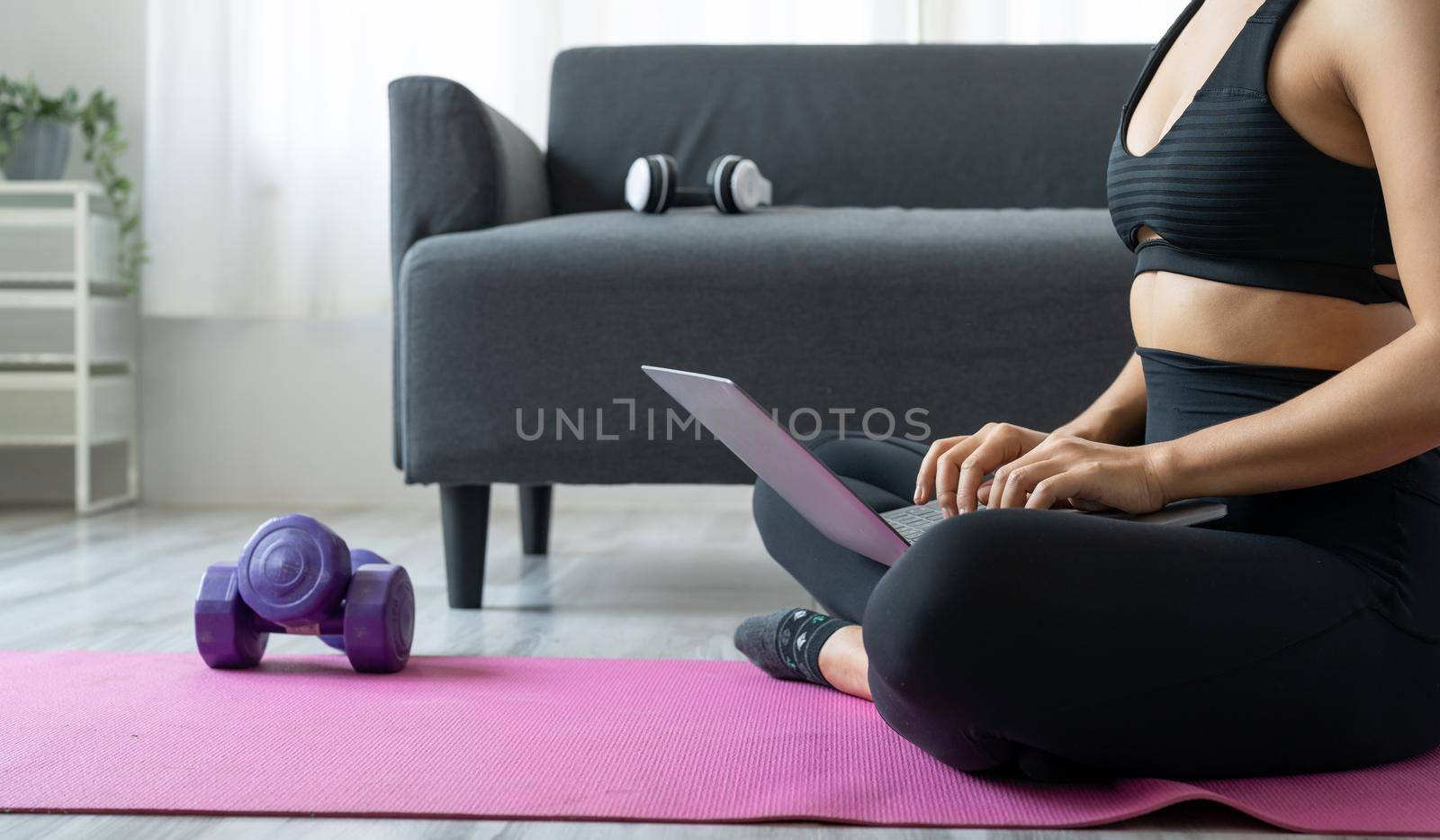 Asian woman with laptop computer at yoga studio - fitness, technology and healthy lifestyle concept.