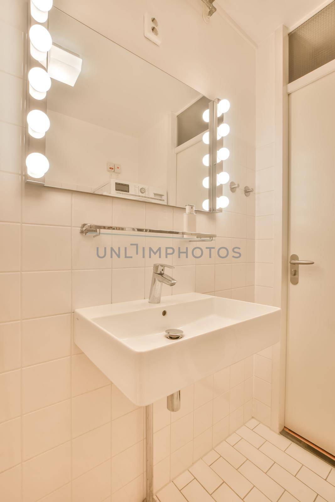 The interior of a bathroom decorated with white tiles by casamedia