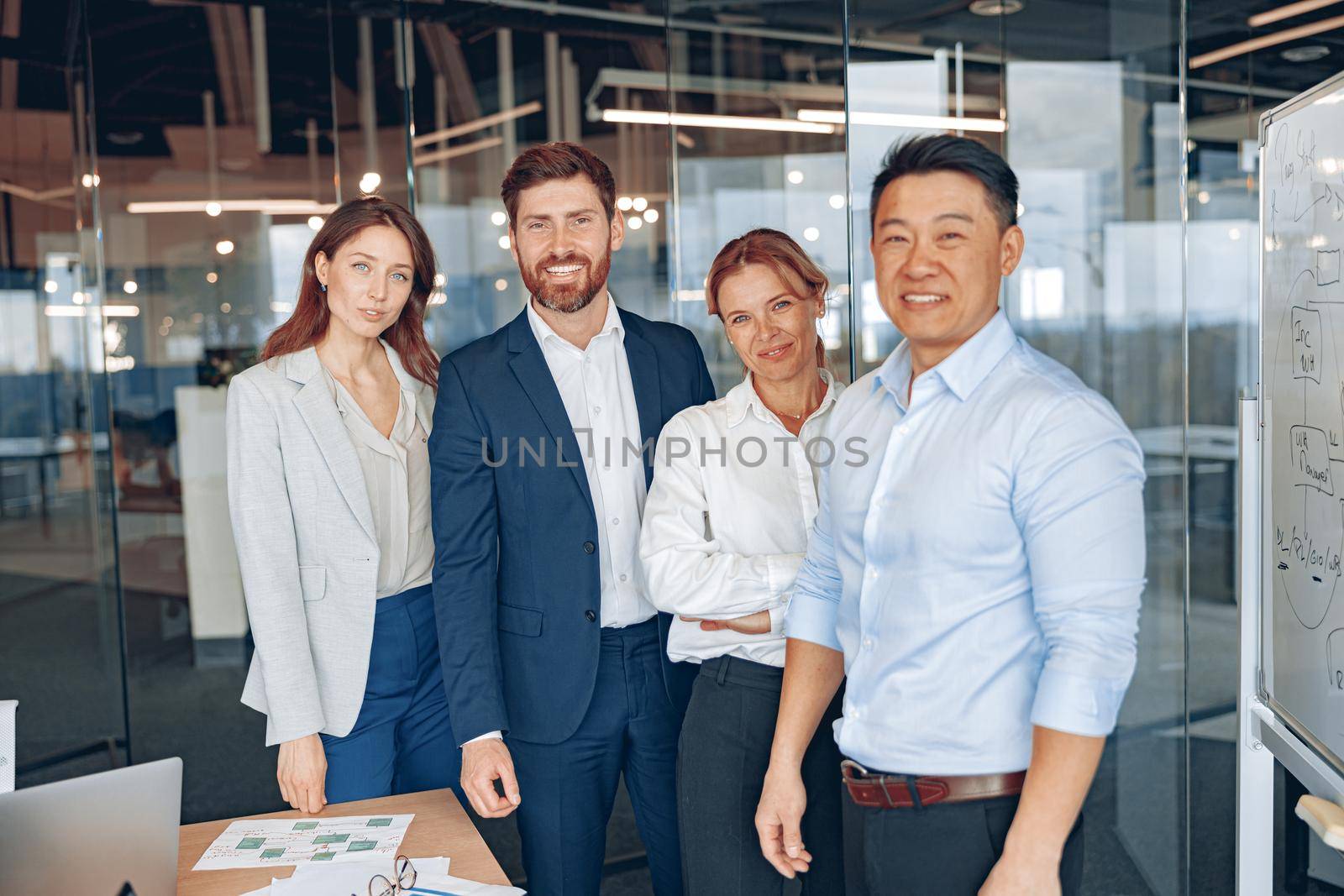 Happy diverse professional business team stand in office near each other looking at camera, smiling by Yaroslav_astakhov