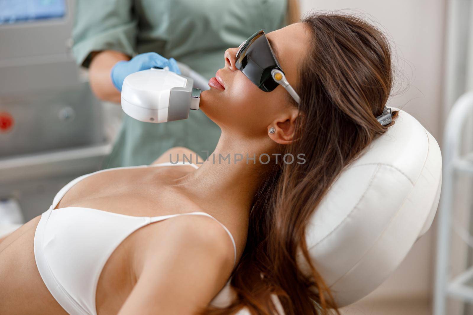 Young woman getting aesthetic face treatment in beauty salon. Cosmetology concept