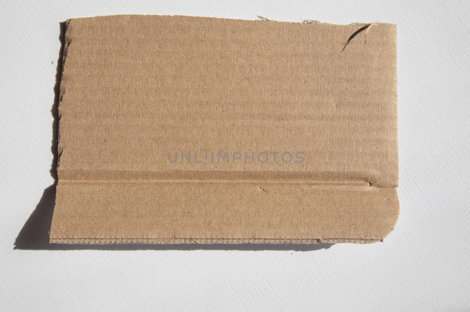 A torn piece of kraft cardboard on a white background. Template, place for text.