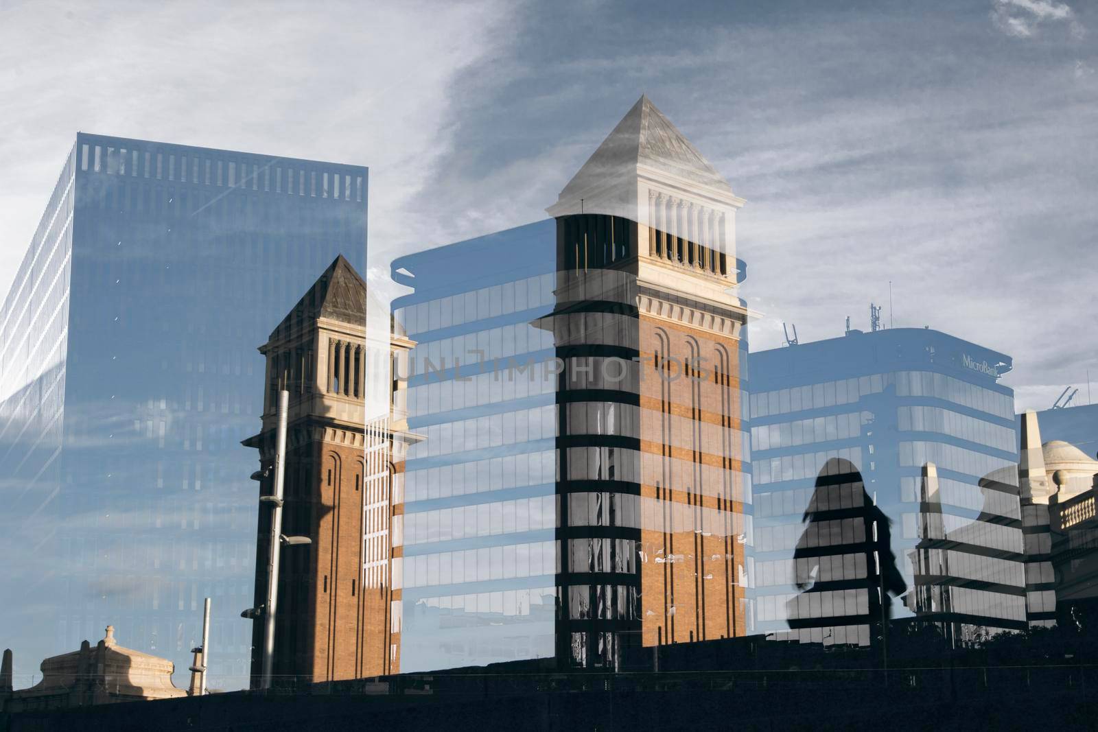 Two towers in Spain square in Barcelona and a little girl dancing next to them and a double exposure composition with some modern buildings