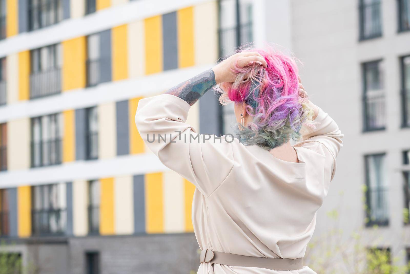 Portrait of a middle-aged woman with multi-colored hair walks on the streets of the city