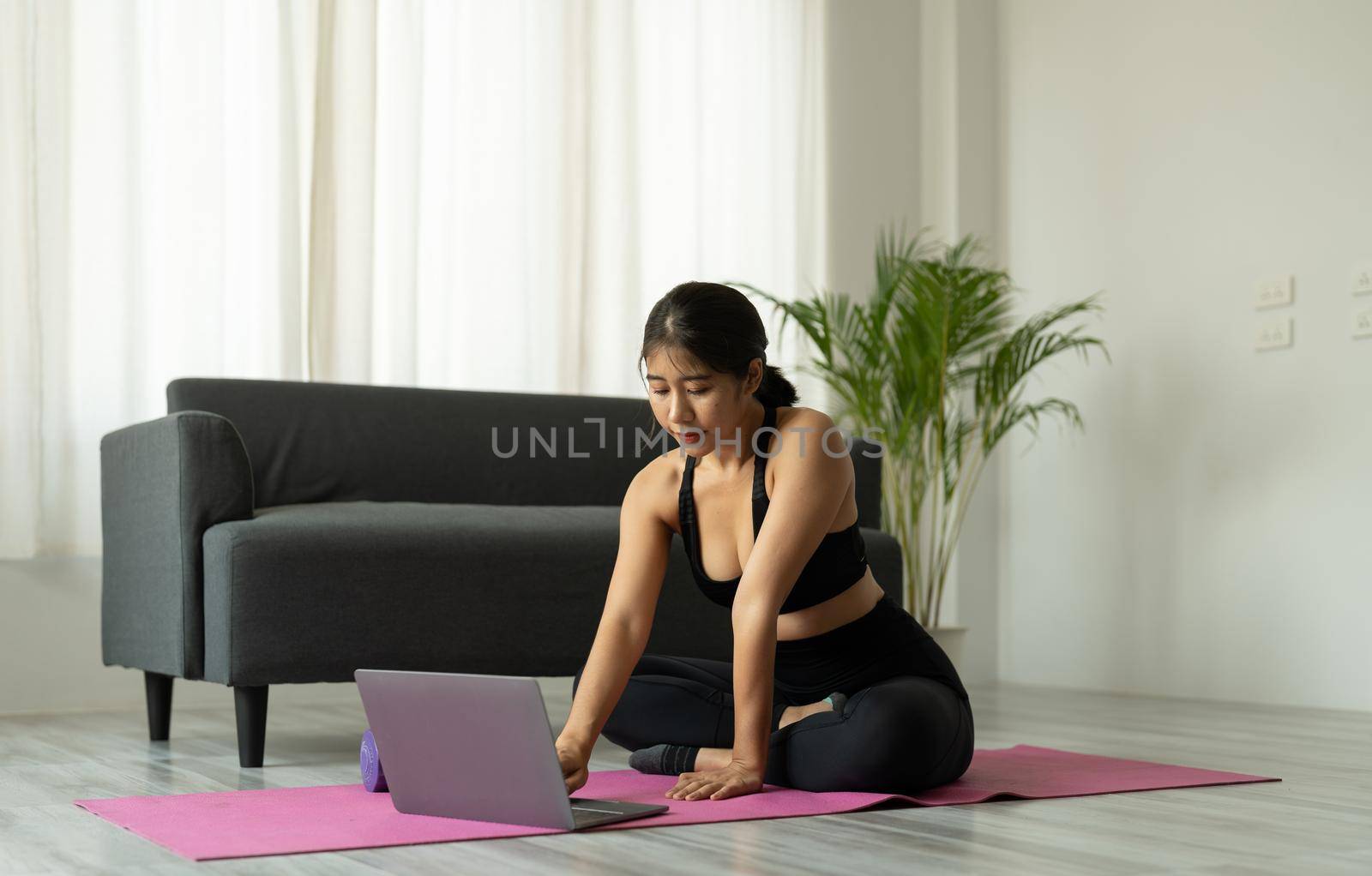 Asian woman with laptop computer at yoga studio - fitness, technology and healthy lifestyle concept.