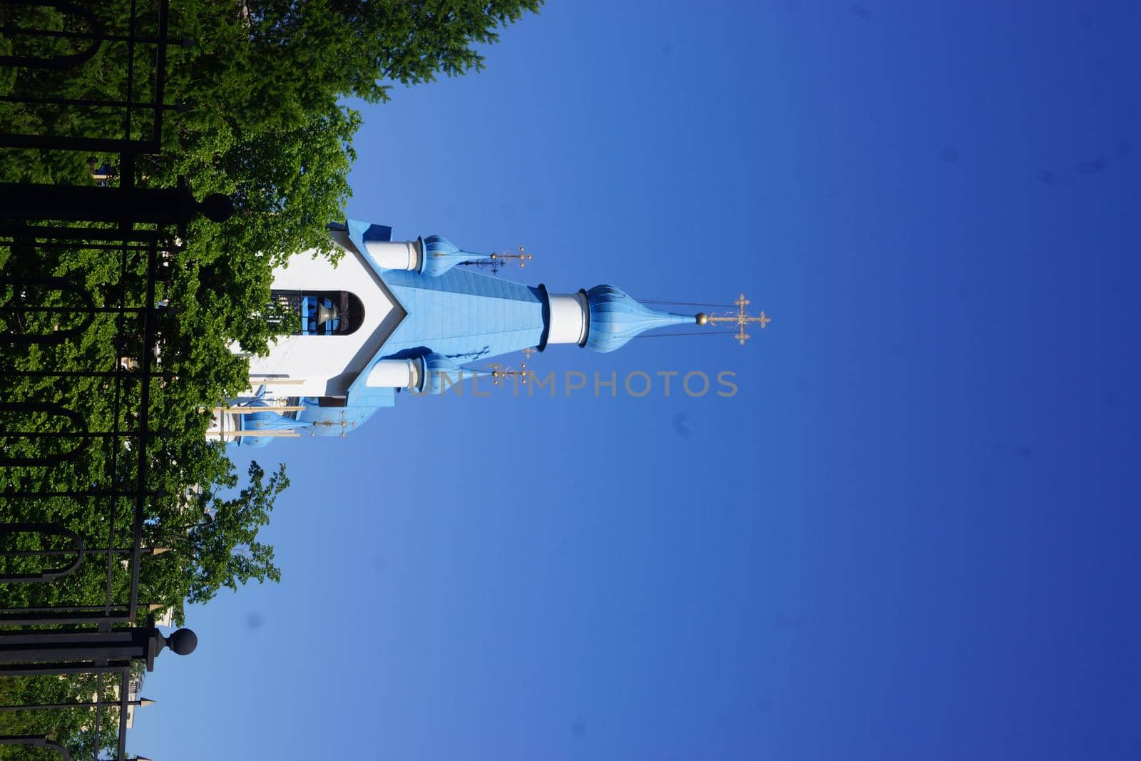 Old church Steeple spire and chimney tops against blue sky by kajasja