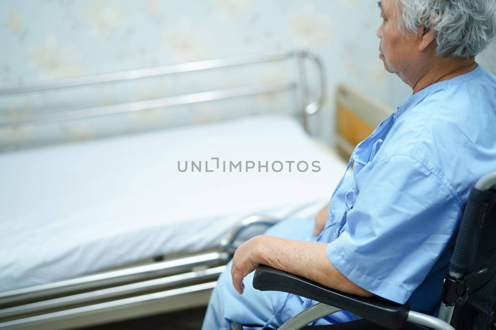 Asian senior or elderly old lady woman patient sitting on wheelchair with bed at nursing hospital ward : healthy strong medical concept