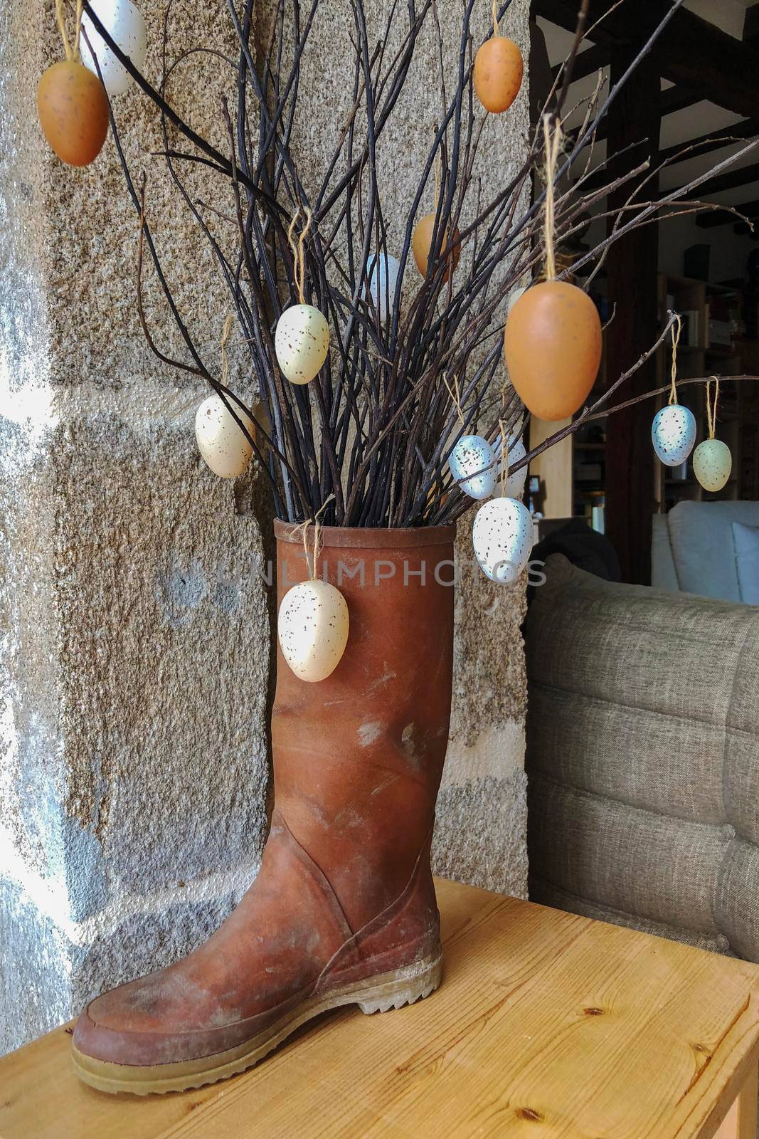 Branches with decorative eggs in a rubber boot Easter