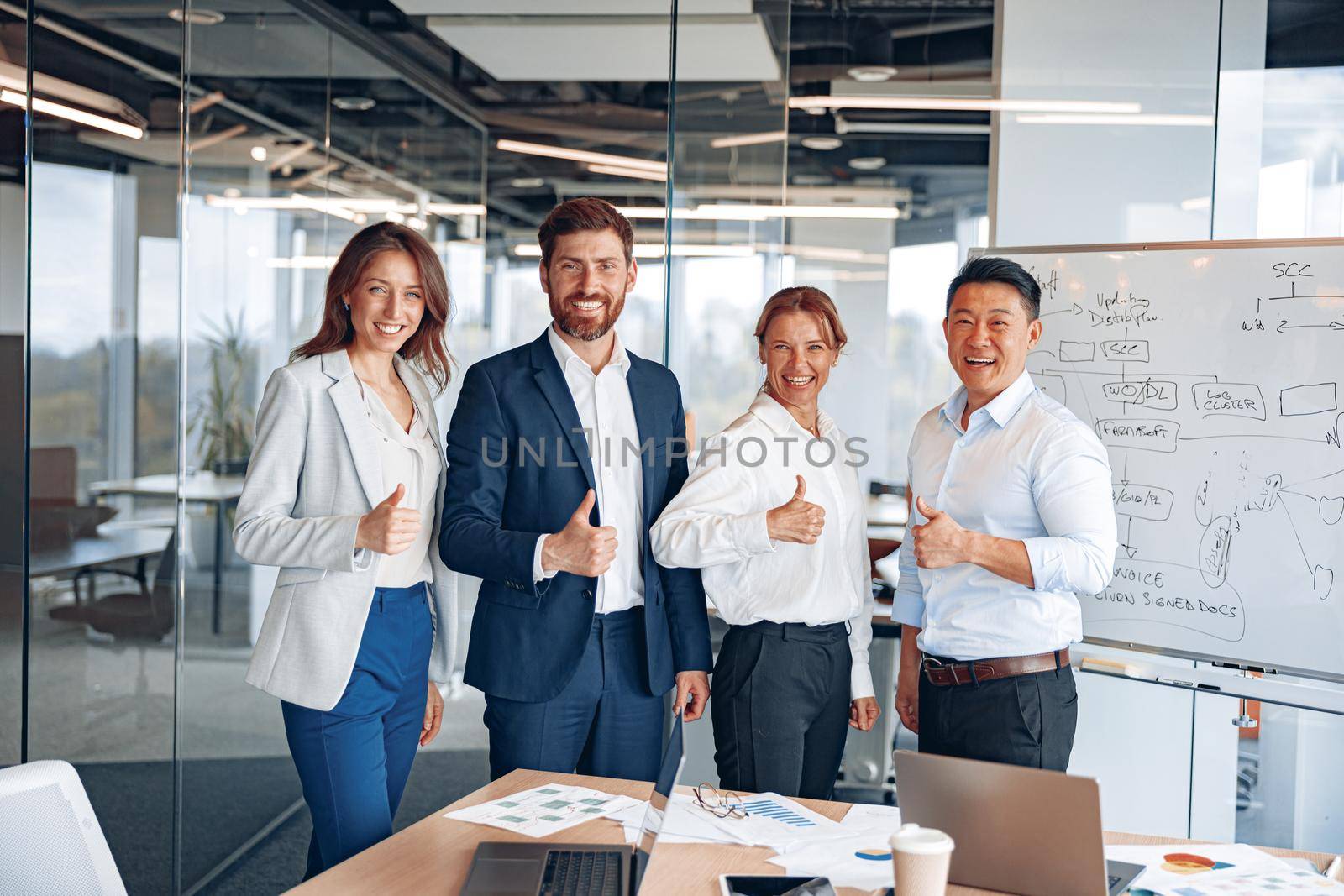 Office employees group showing thumbs up looking at camera, happy professional multicultural team.