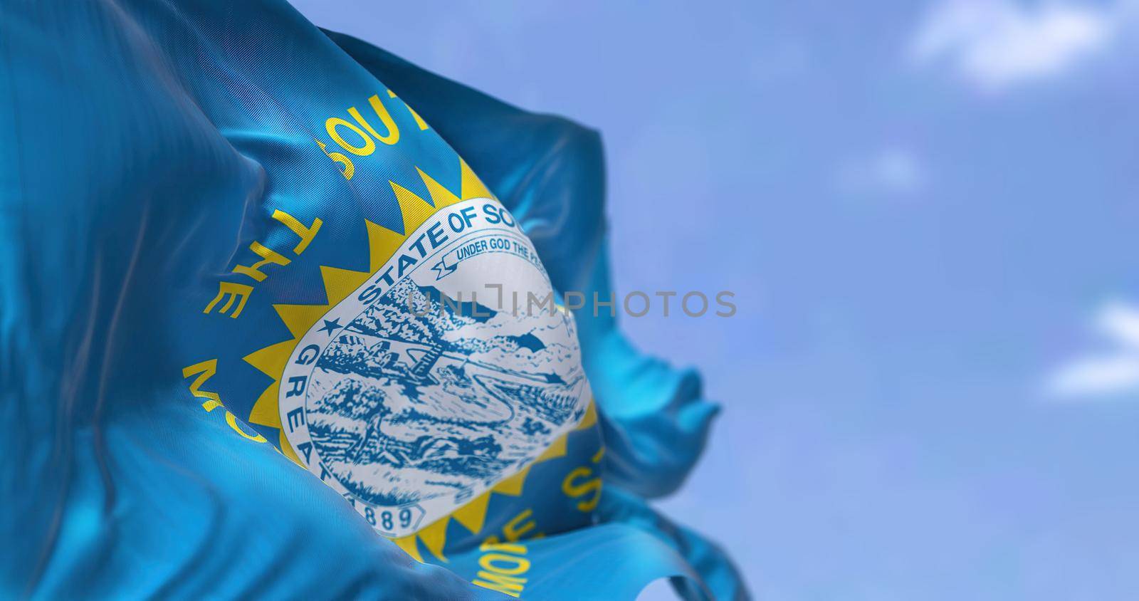 The US state flag of South Dakota waving in the wind. South Dakota is a U.S. state in the North Central region of the United States. Democracy and independence.