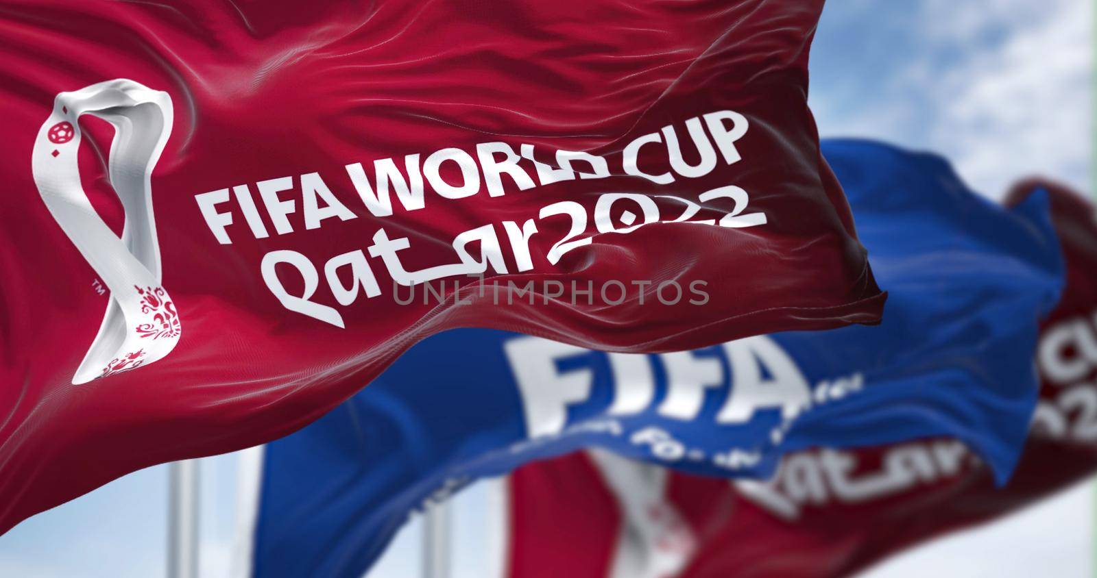Doha, Qatar, April 2022: Flags with Qatar 2022 World Cup logo and FIFA waving in the wind. The event is scheduled in Qatar from 21 November to 18 December 2022