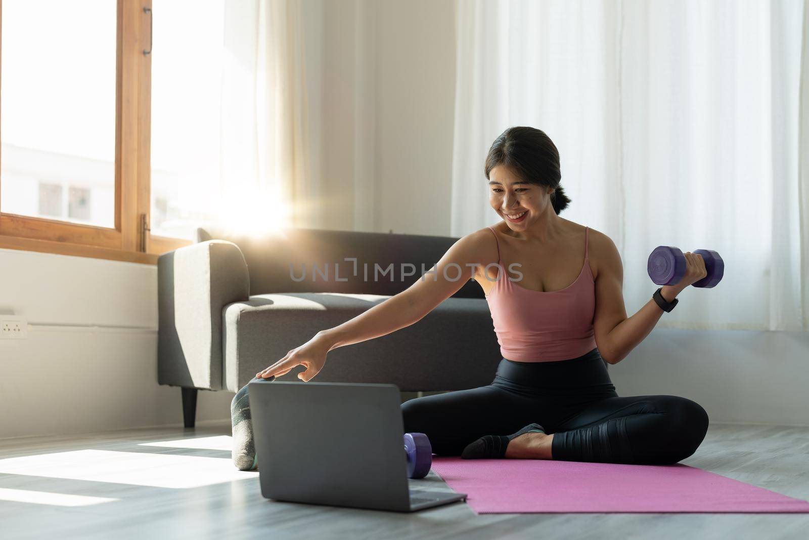 Young woman is exercising yoga at home. Fitness, workout, healthy living and diet concept.