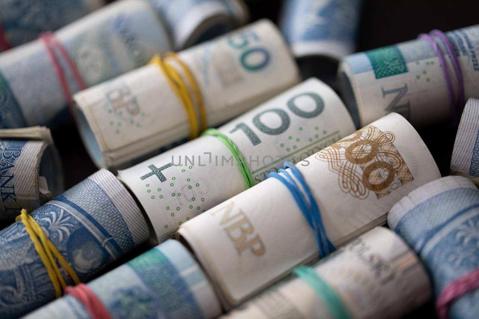 Rolled banknotes with the face value of two hundred zlotys and one hundred and fifty zlotys. Rolled and fastened with a rubber band.