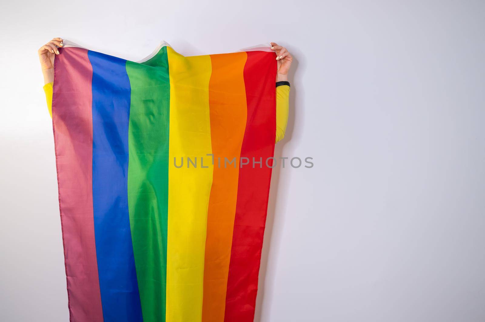 Caucasian woman holding lgbt flag covering herself. by mrwed54