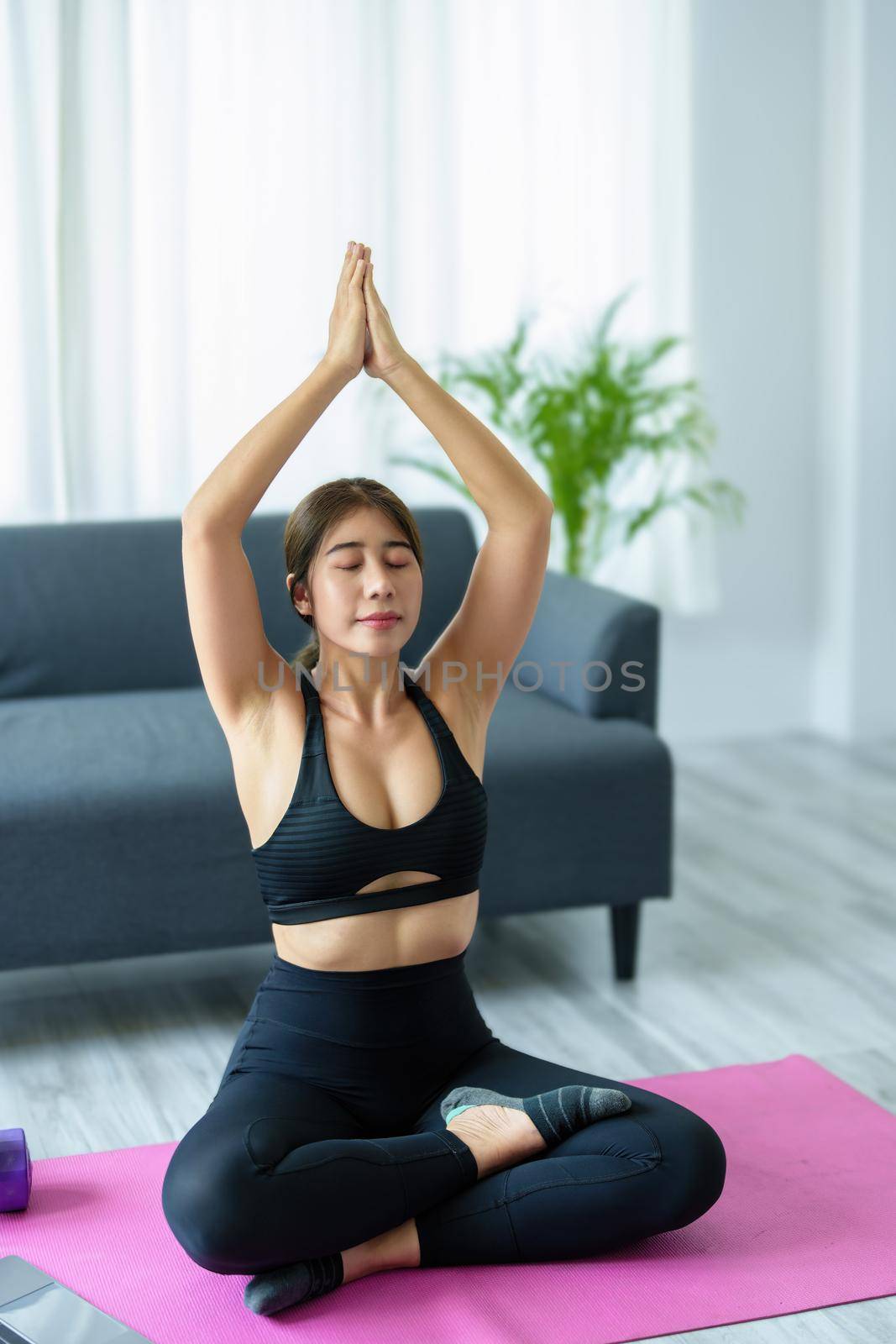 stress relief, muscle relaxation, breathing exercises, exercise, meditation, portrait of Young Asian woman relaxing her body from office work by practicing yoga by watching online tutorials. by Manastrong