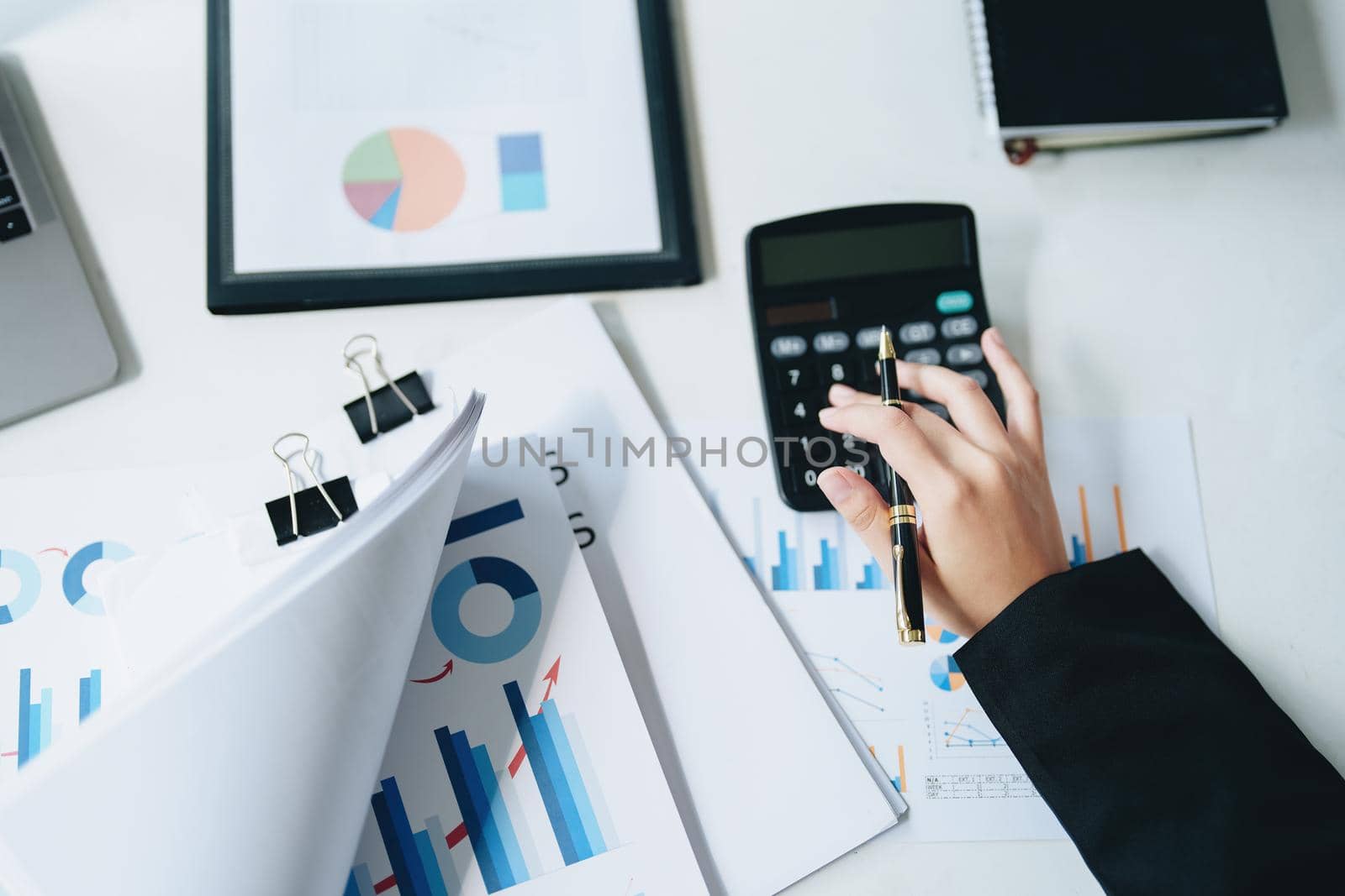 accountant, Auditor, Self-Employed, Finance and Investment, tax calculation and budget, Asian female entrepreneur using a calculator to calculate. Company business results document