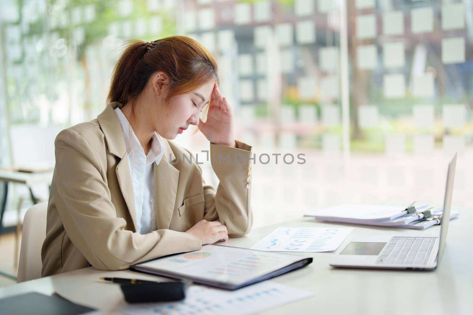 Burnout Syndrome. Portrait of Asian Business Woman feels uncomfortable working. Which is caused by stress, accumulated from unsuccessful work And less resting body. Consult a specialist psychiatrist. by Manastrong