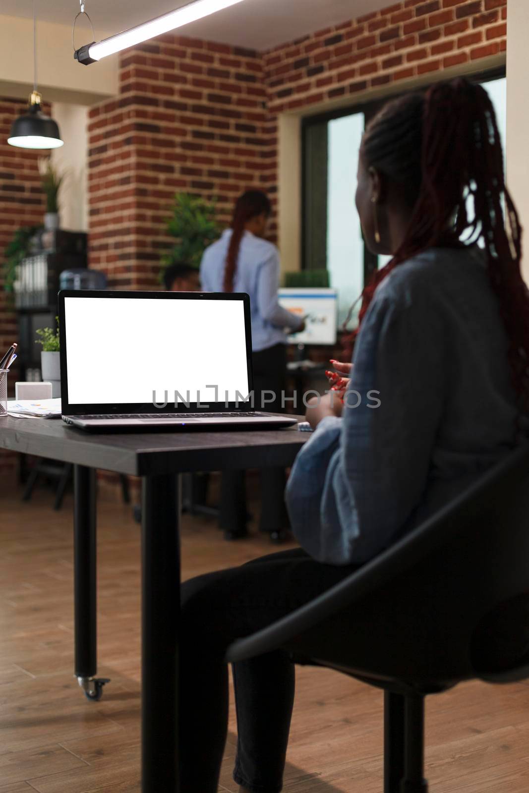 Business company employee working on computer with chroma key and isolated template. Mockup image of businesswoman sitting at desk in office with whitescreen display work laptop