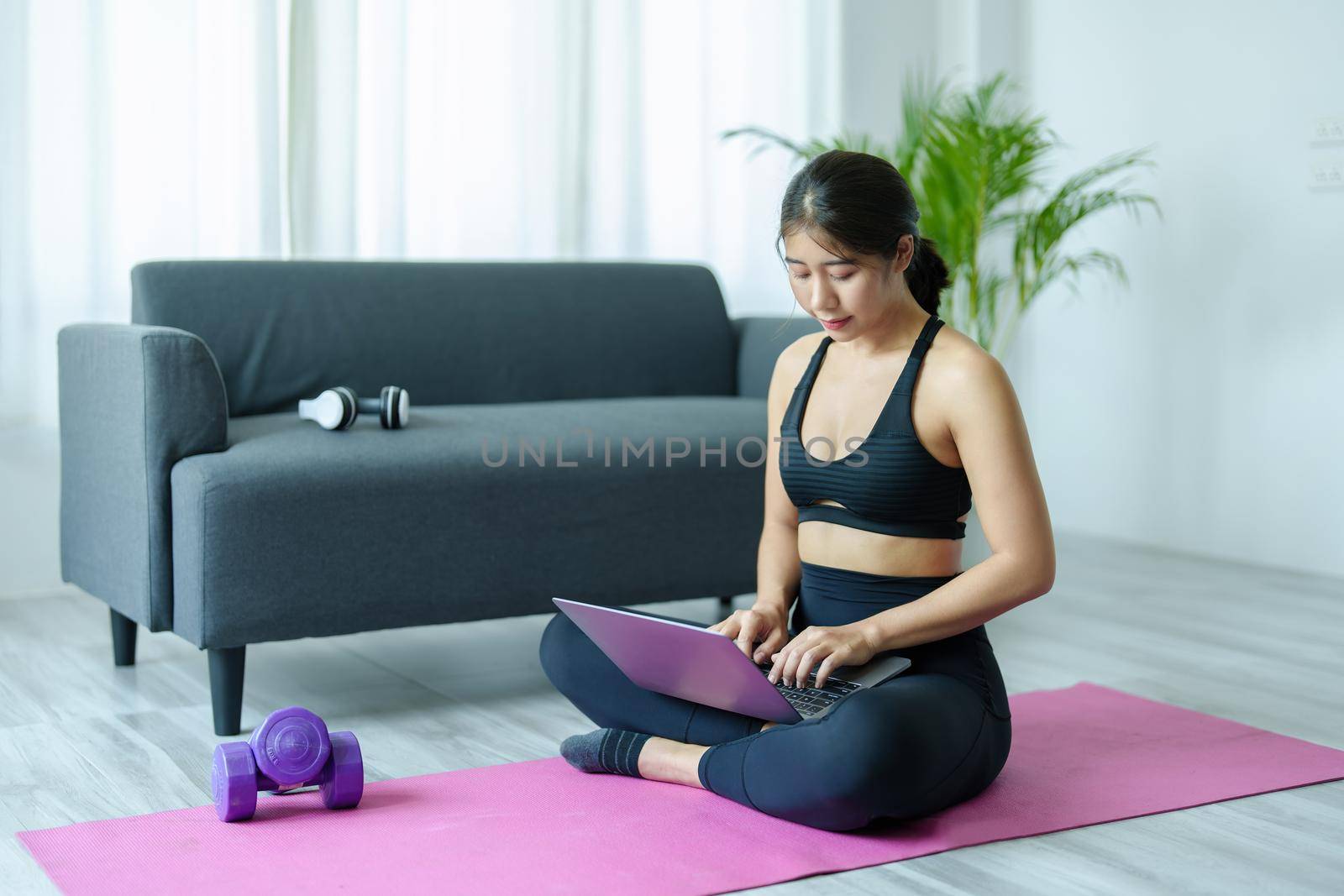 stress relief, muscle relaxation, breathing exercises, exercise, meditation, portrait of Young Asian woman relaxing her body from office work by practicing yoga by watching online tutorials