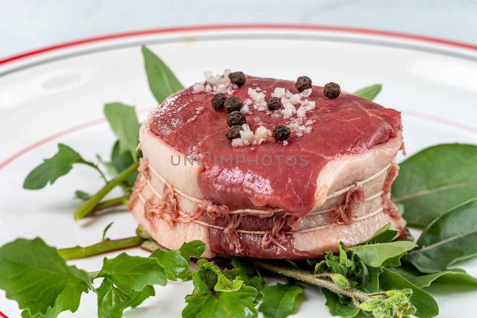 Close-up of a raw tournedos placed on the chew.