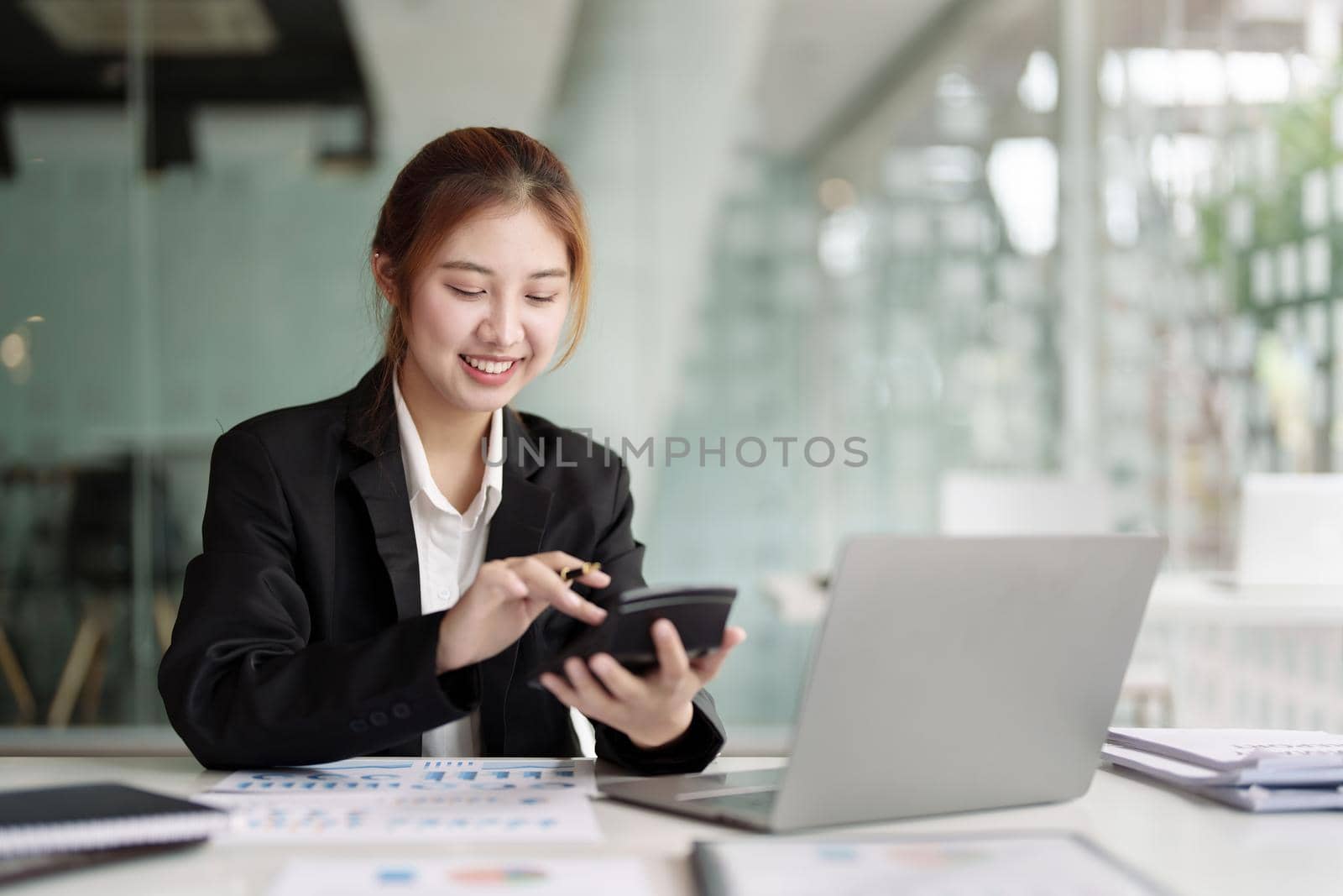 accountant, Auditor, Self-Employed, Finance and Investment, tax calculation and budget, Portrait of Asian female entrepreneur using a calculator to calculate. Company business results document