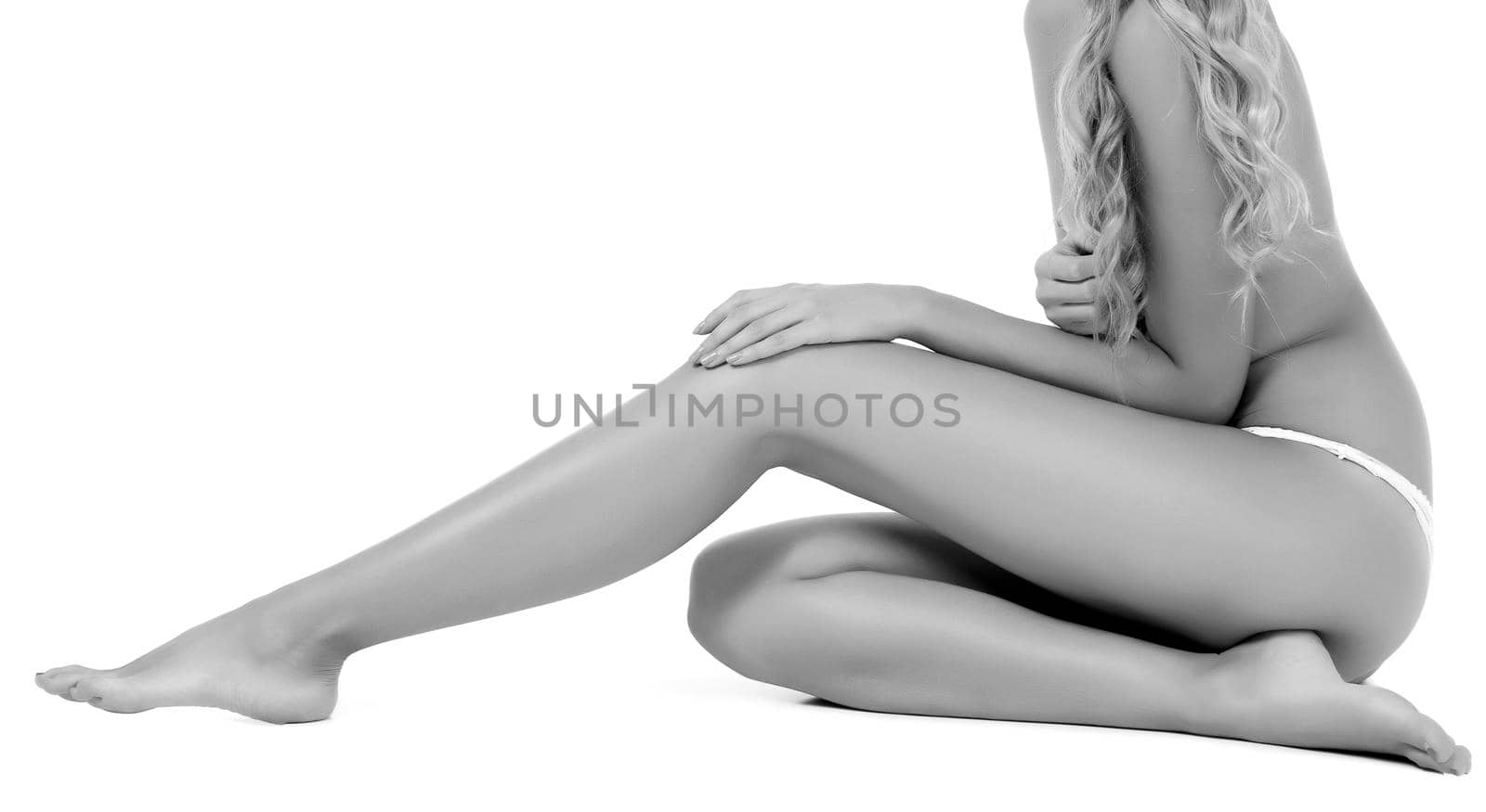 Woman touches her leg, isolated on white