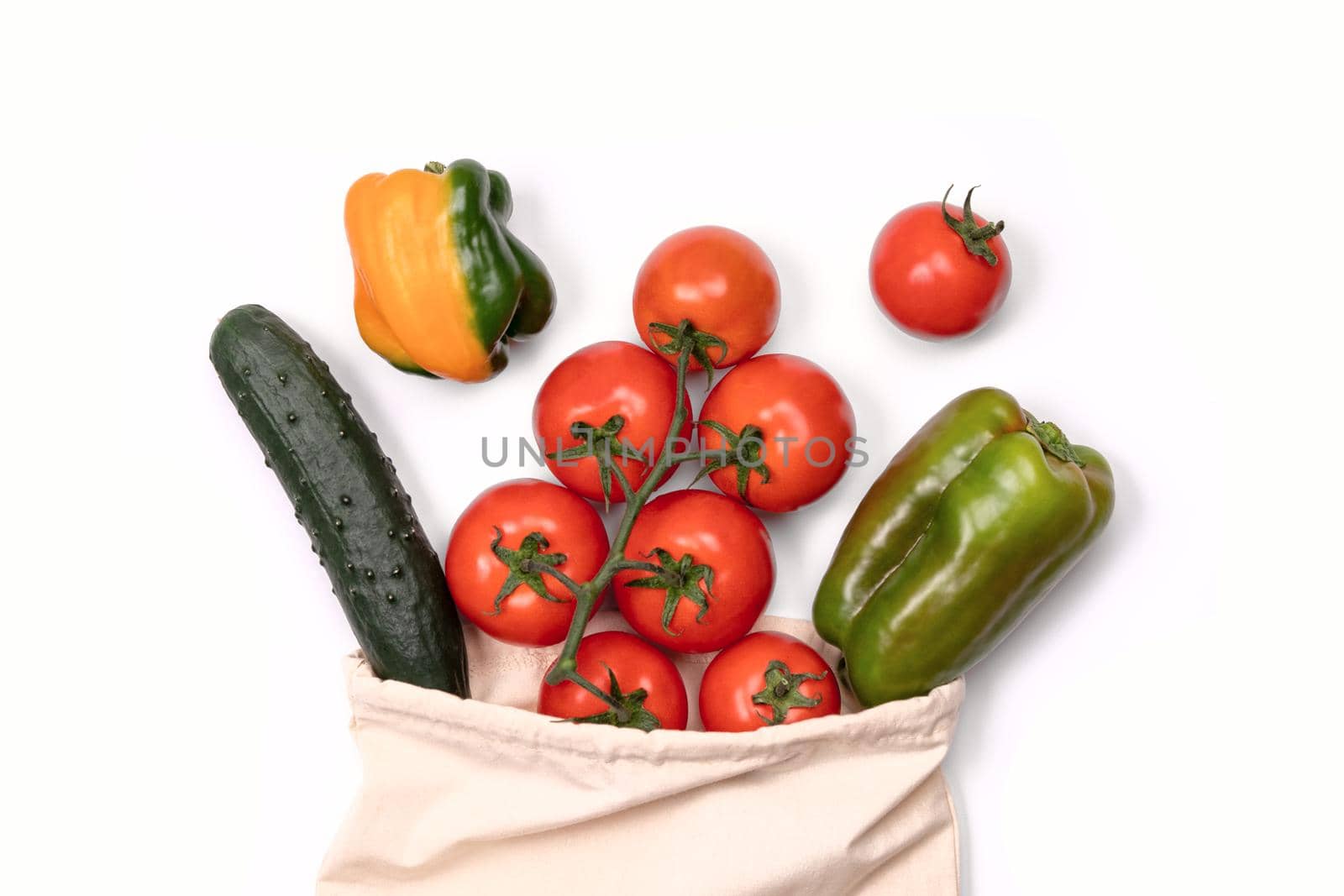 Summer vegetables in reusable eco friendly cotton bag on white. Zero waste, plastic free shopping, ecological concept. by photolime