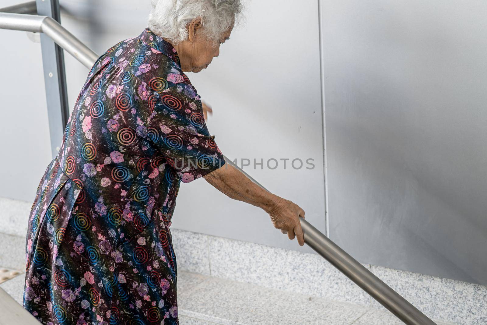 Asian senior or elderly old lady woman patient use handle at stairs security support in building, healthy strong medical concept. by pamai