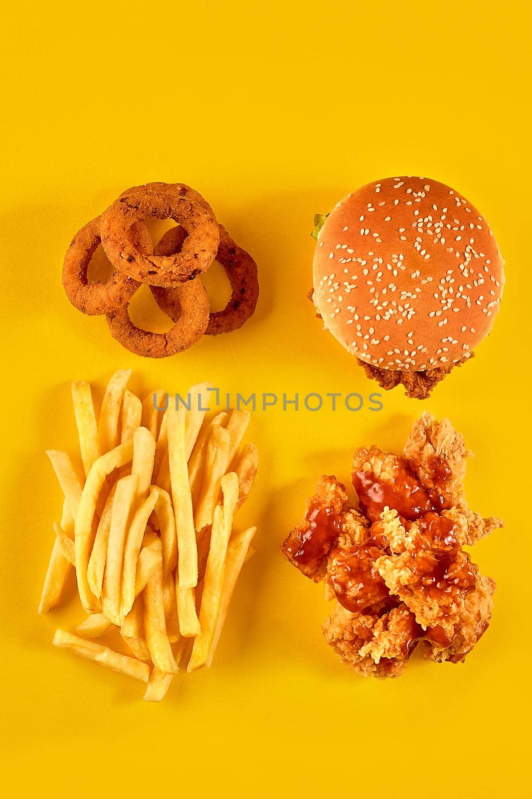 Fast food dish on yellow background. Fast food set fried chicken, meat burger and french fries. Take away fast food. Top view. Copy space. Still life. Flat lay.