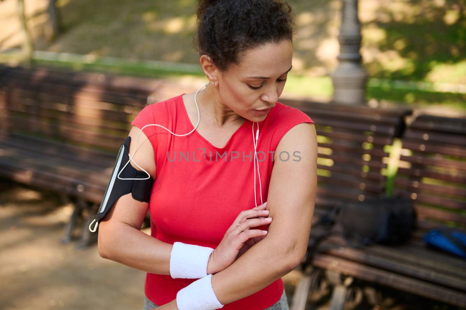 Portrait of a middle aged beautiful Hispanic woman with healthy clean fresh skin and aesthetic fit muscular body in sportswear standing on the city park while working out. Sport, fitness concept