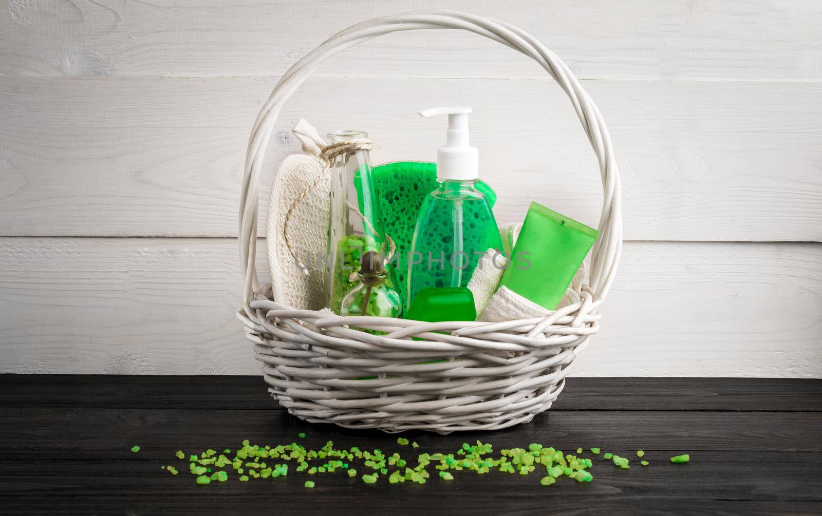 Green composition beauty treatment products in green colors: shampoo, soap, bath salt, oil. Various bath accessories. Items for the spa. Still life. Copy space