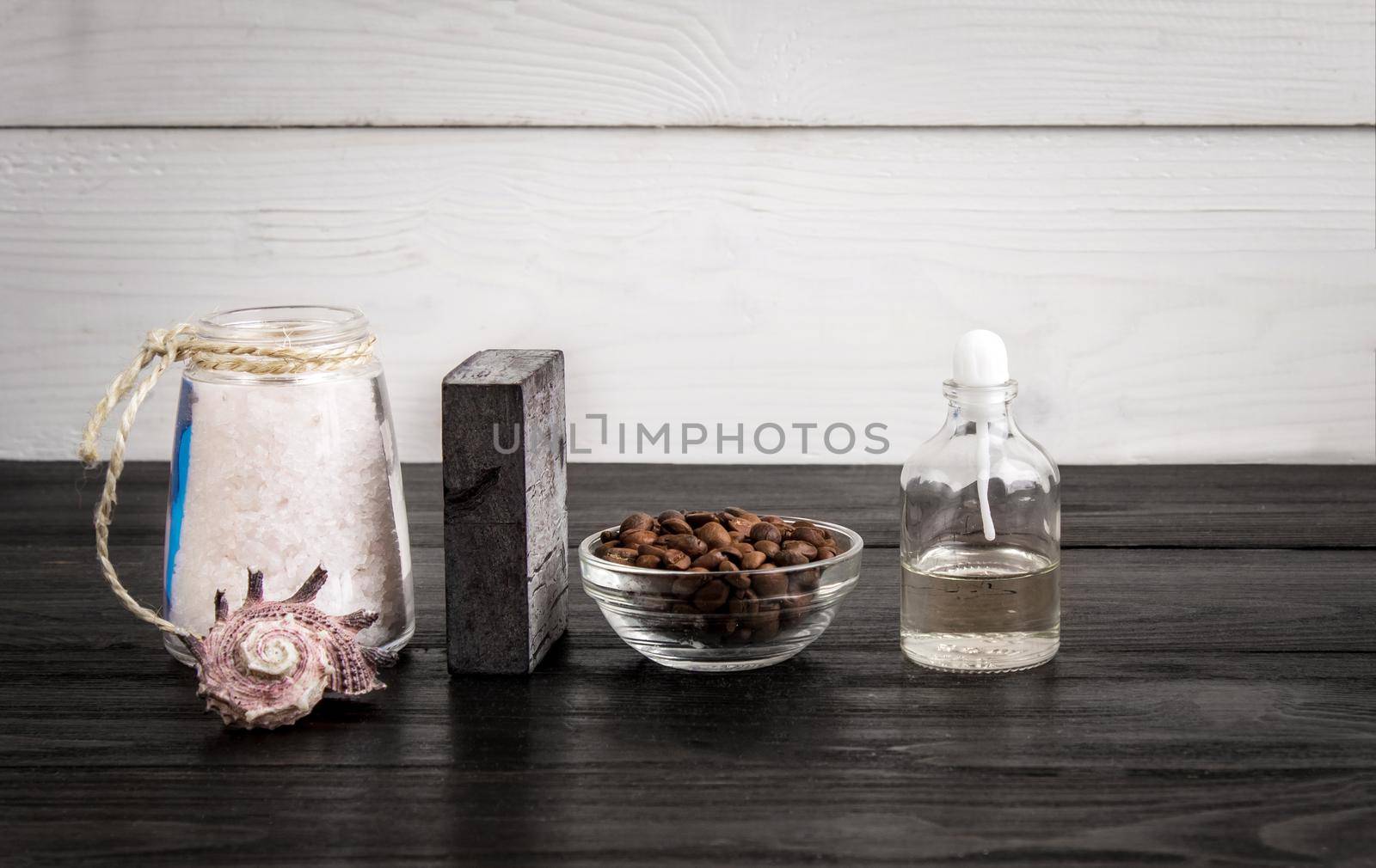 Spa still life. Aroma oils, stones, soap, sea salt and coffee beans on wooden background. Various bath accessories. Items for the spa. Copy space
