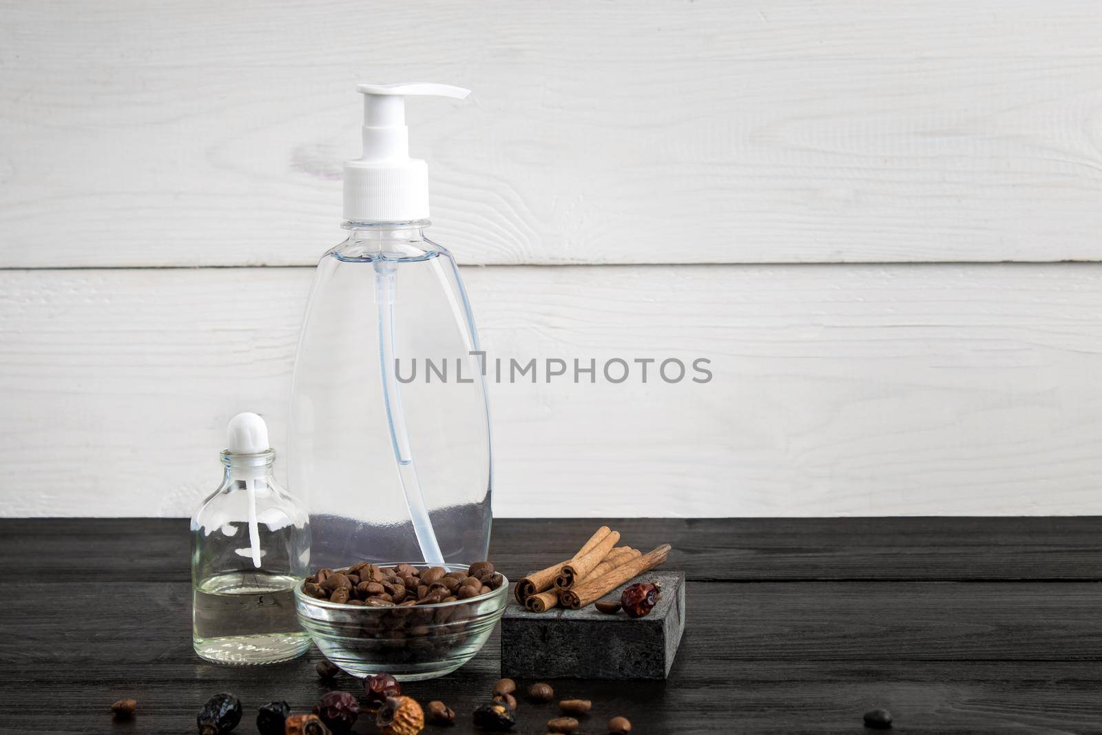 Spa still life. Aroma oils, stones, soap, shampoo and coffee beans on wooden background. Various bath accessories. Items for the spa. Copy space