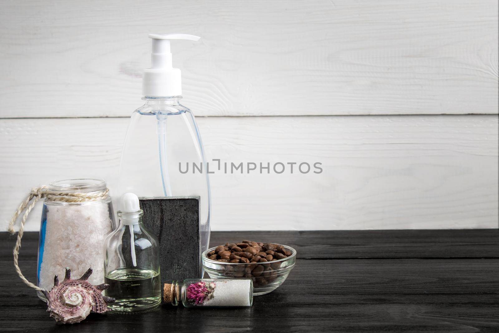 Spa still life. Aroma oils, stones, soap, sea salt and coffee beans on wooden background. Various bath accessories. Items for the spa. Copy space