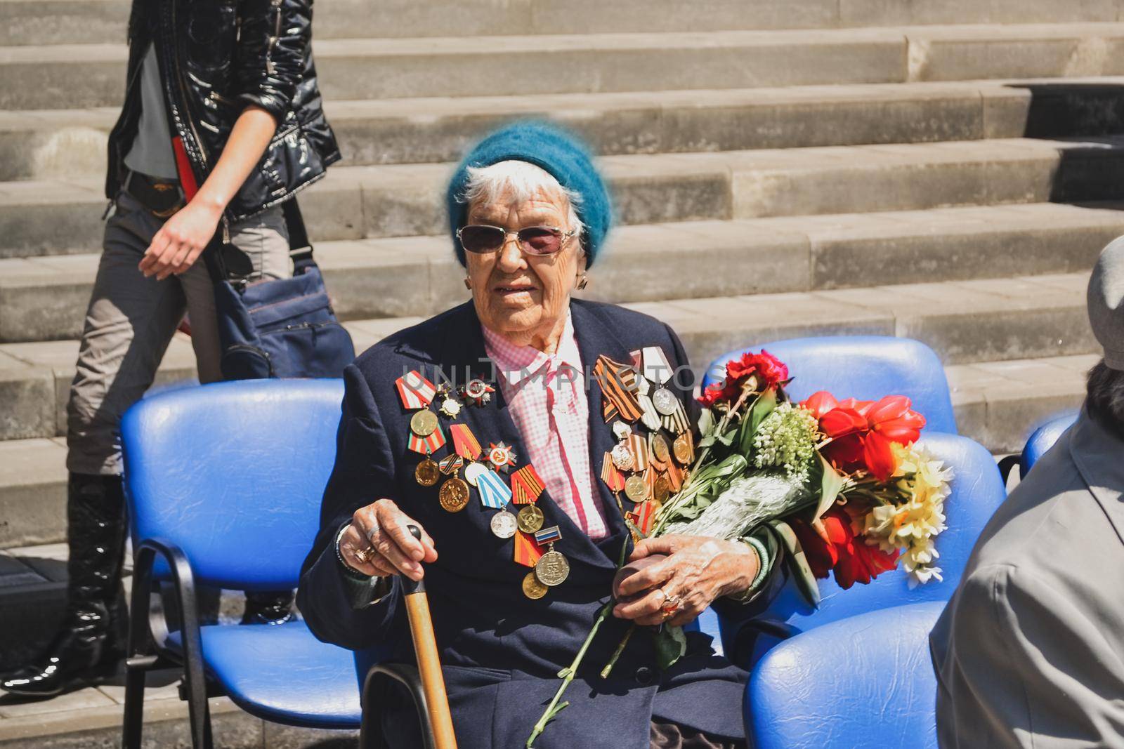 PYATIGORSK, RUSSIA - MAY 09, 2011: War veteran woman with flowers on the Victory Day celebration. Russian babushka
