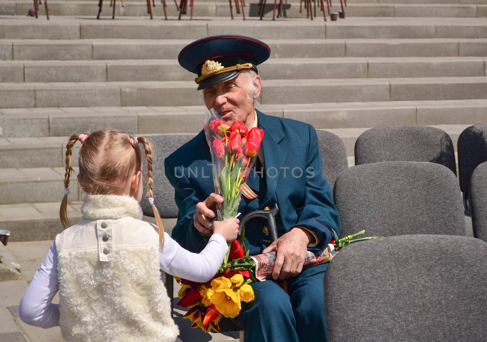 PYATIGORSK, RUSSIA - MAY 09, 2011: Girl gives flowers to veteran on Victory Day. 9 may