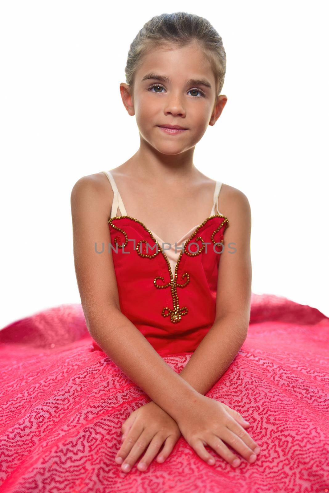 portrait of a beautiful little ballerina in a performance red dress dreaming to become professional ballet dancer. isolated on the white background