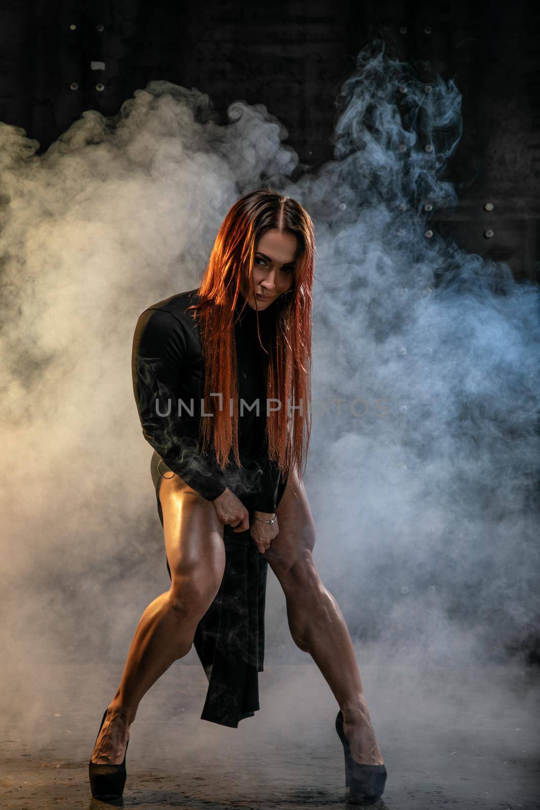 Attractive red-haired girl in black dress demonstrates athletic legs by but_photo