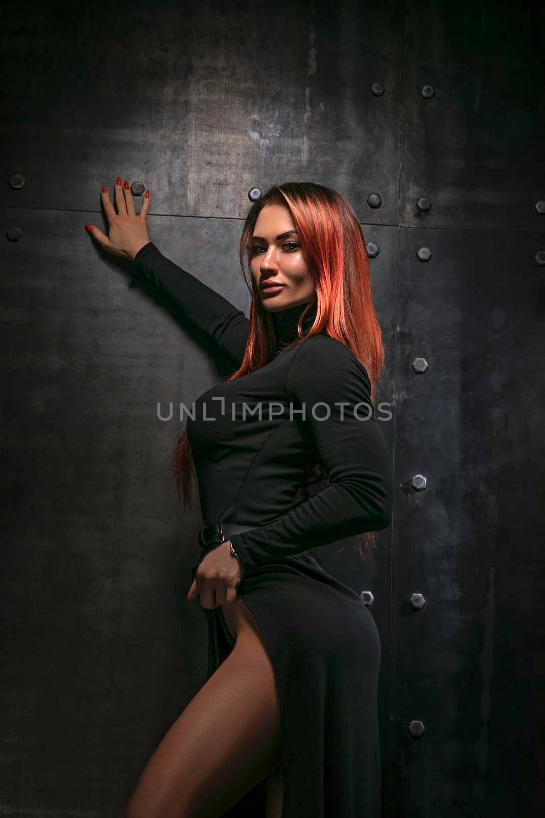 Beautiful redhead girl in black dress posing for camera at studio by but_photo