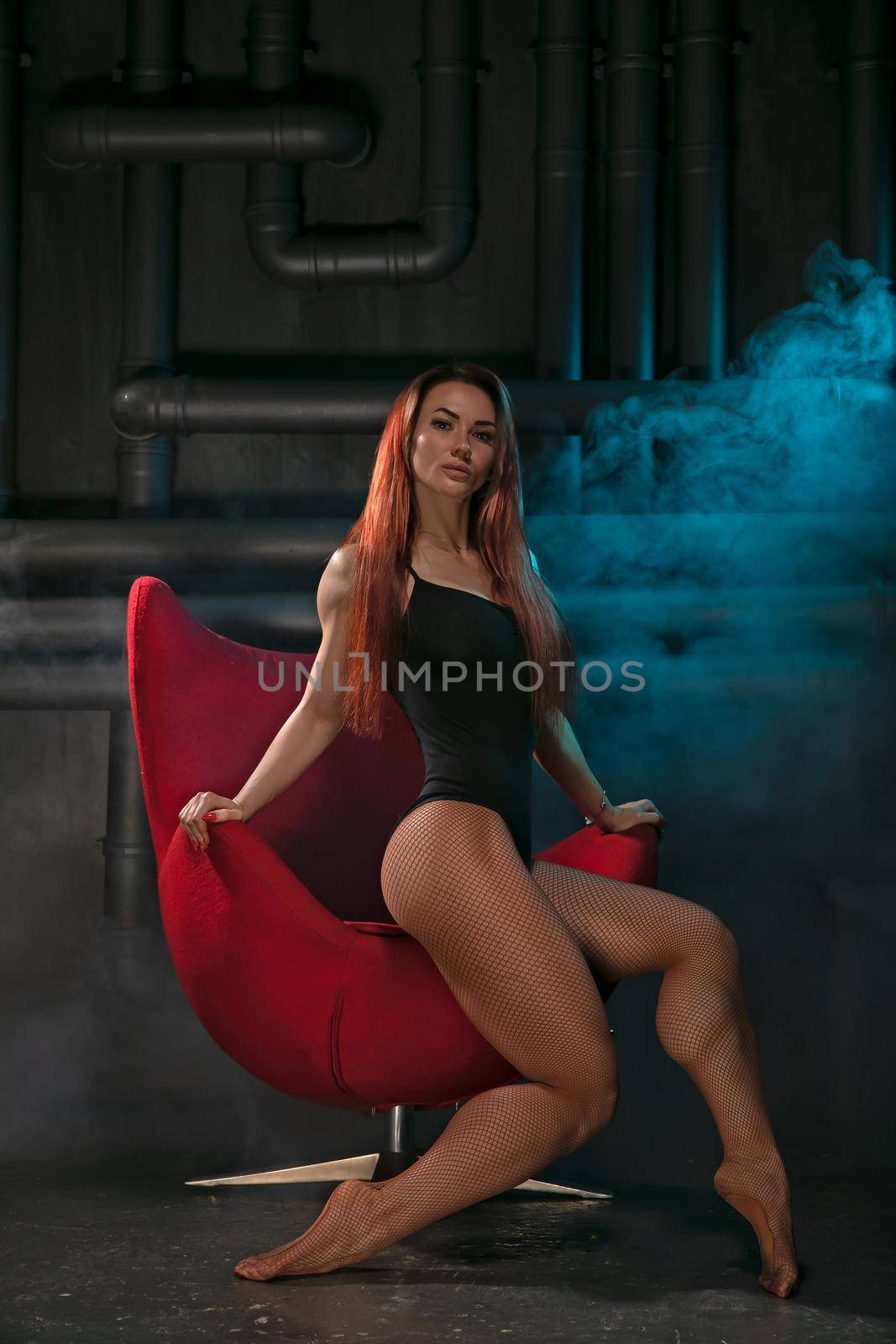 Bright girl with sexy legs posing in a red chair by but_photo