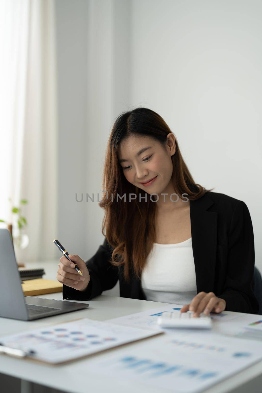 Portrait asian accountant woman hand press on calculator for make financial report or company's profit monthly at desk , bookkeeper job and work from home concept by nateemee
