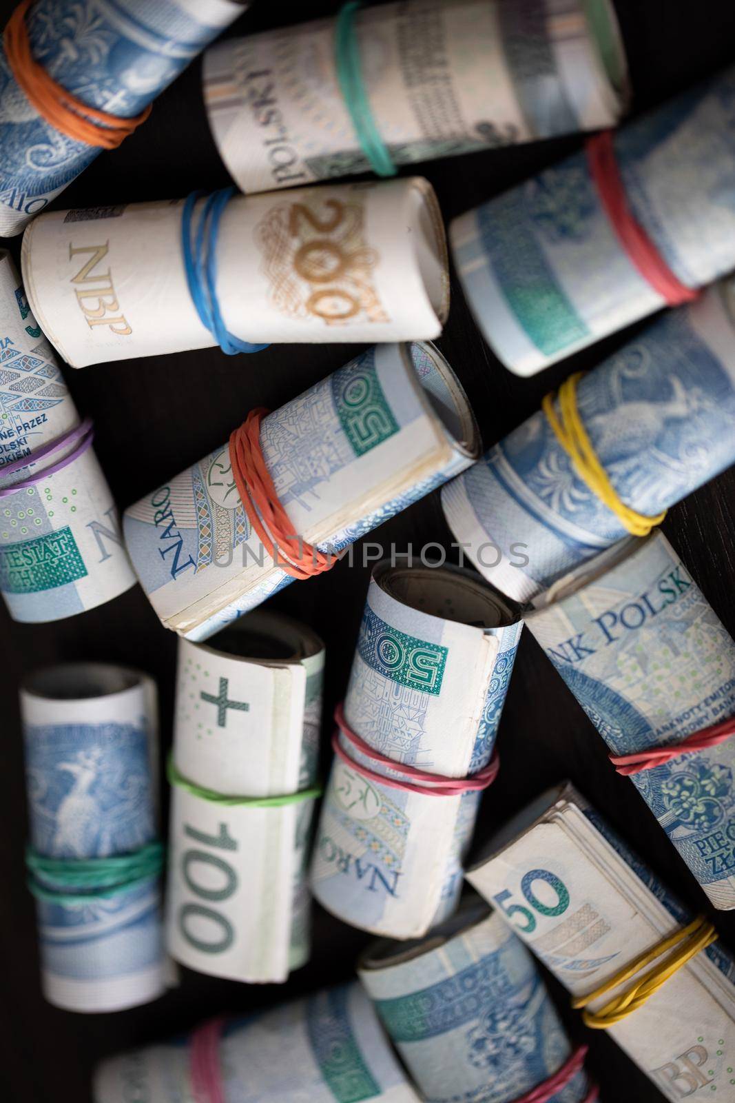 Rolled banknotes with the face value of two hundred zlotys and one hundred and fifty zlotys. Rolled and fastened with a rubber band.