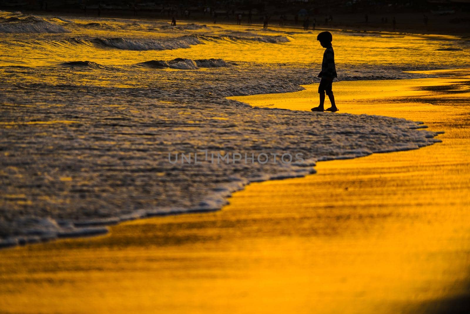 Kid playing at dusk waves. Shooting Location: Kamakura City, Kanagawa Prefecture