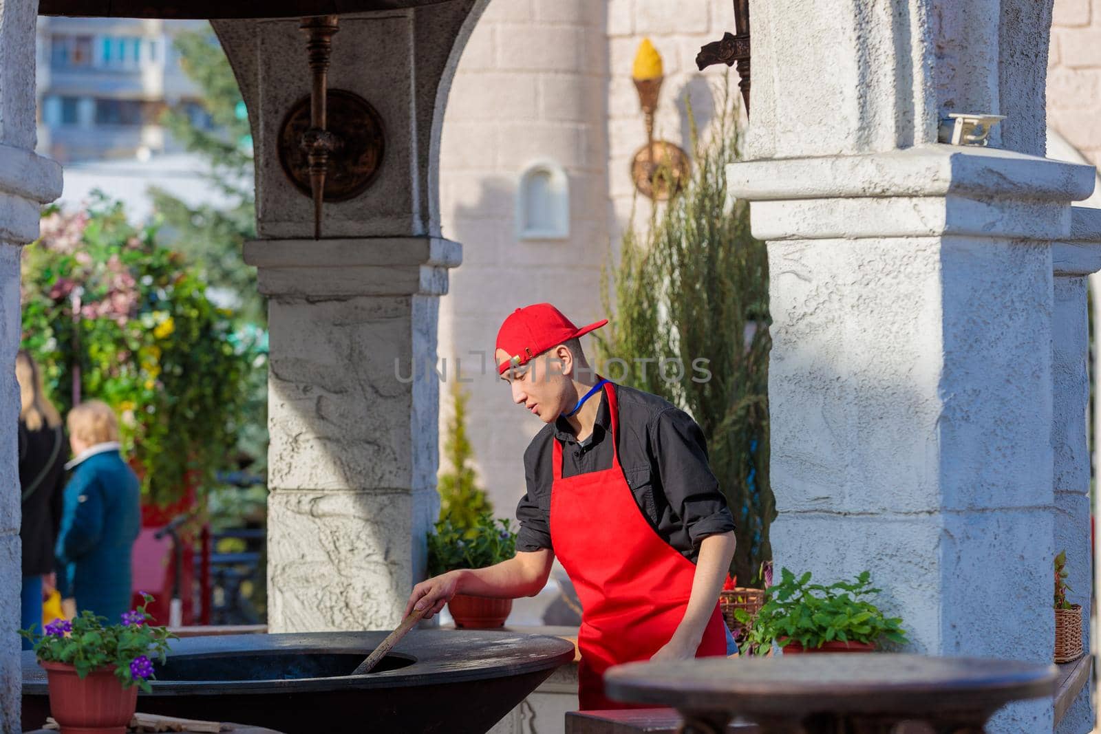 A man prepares an oven in a street cafe for cooking. Moscow Russia April 23, 2022.