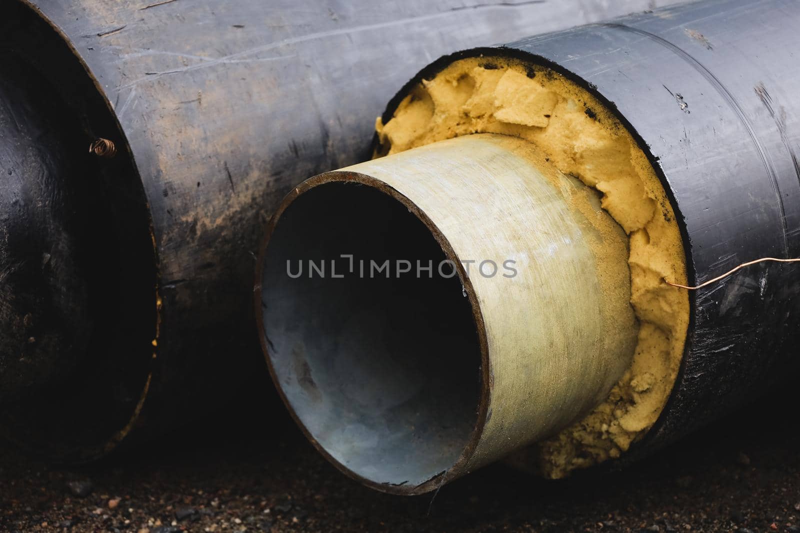 Pre-insulated pipe. Steel pipe with an upper layer of polyurethane foam insulation. Thermal insulation. Modern pipeline for supplying hot water and heating to a residential area. Industrial concept.