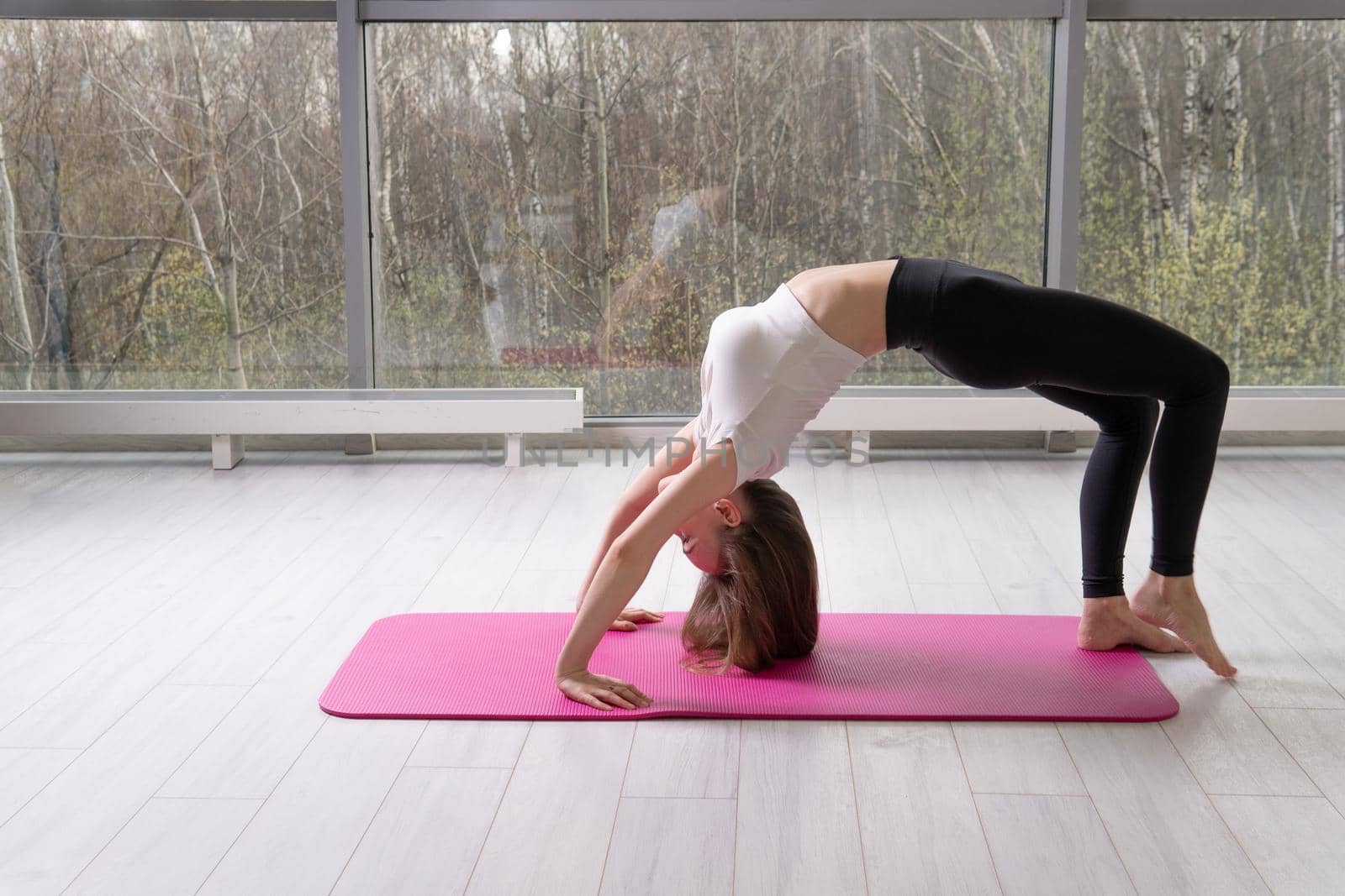 Pose on the bridge in the mat the of Stands fitness red mfr, from fit home in cheerful from sport person, pilates stretching. Motivation slim position, leg smiling practicing pose