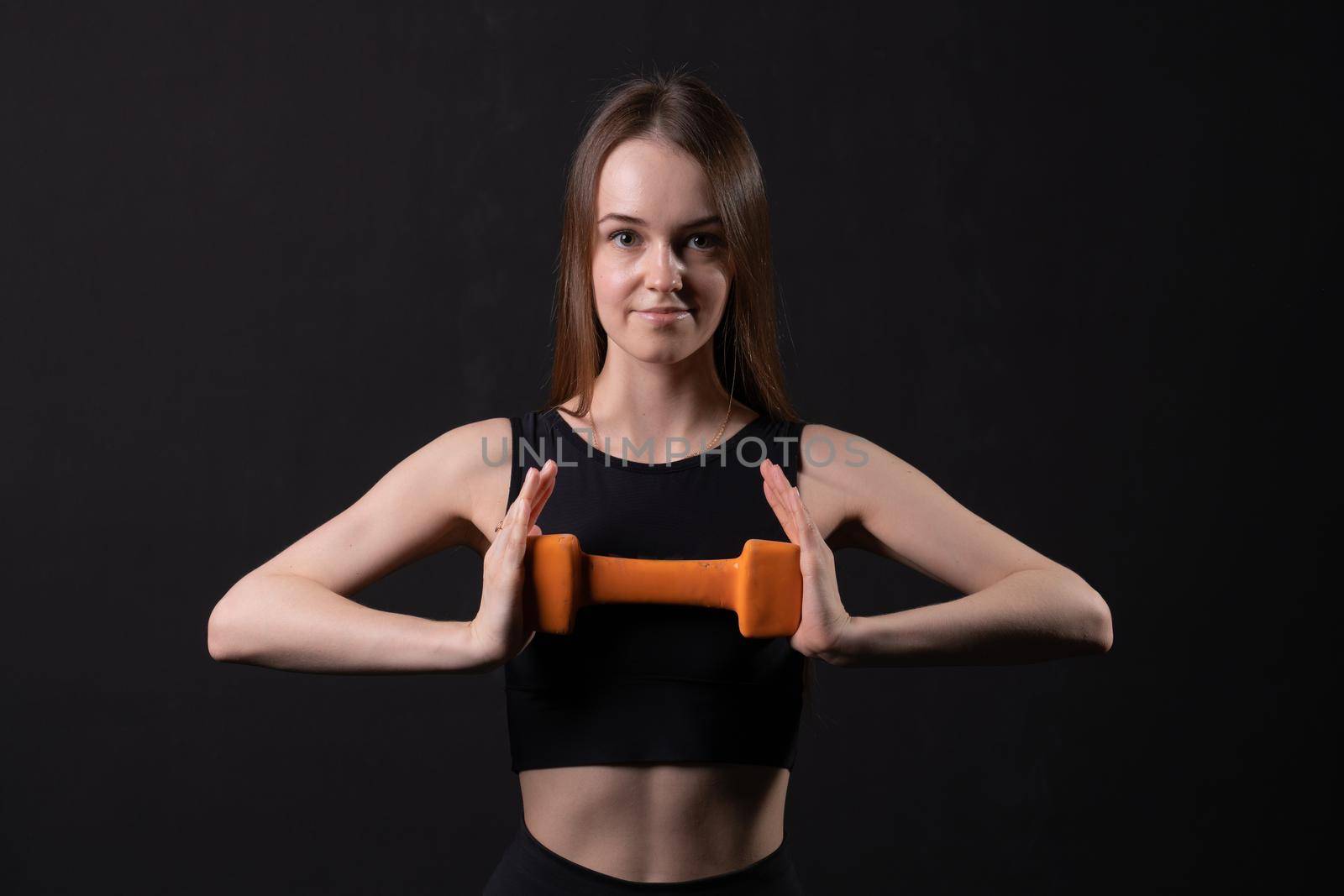 Beautiful with on black background orange dumbbells a maiden . Orange two gym, for exercise body in woman and weight diet, muscle loss. Fat big joy, figure young overweight doing by 89167702191